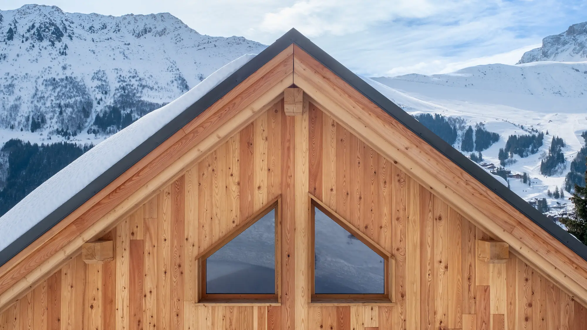 Alpen-Chalet aus Holz vor verschneiten Bergen
